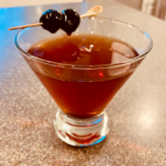 Cocktail glass of Bar Drake Manhattan garnished with cherries